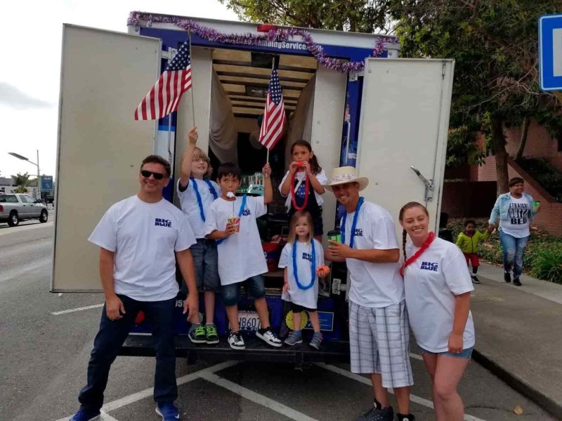 Family posing in front of truck with american flags